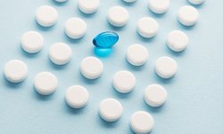 une-capsule-liquide-bleue-dans-une-grille-de-comprimes-blancs